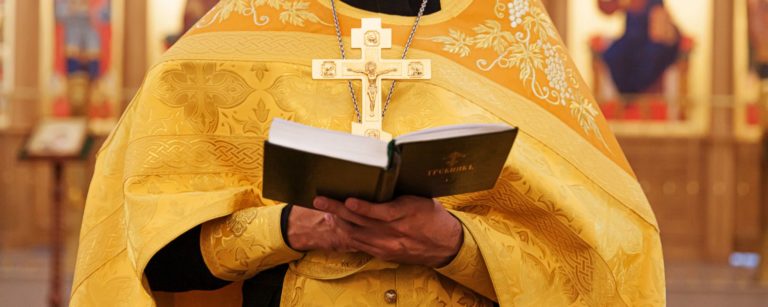 priest-hands-holding-holy-bible-book-in-church