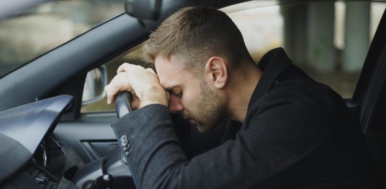 Young man sitting inside car is very upset and stressed