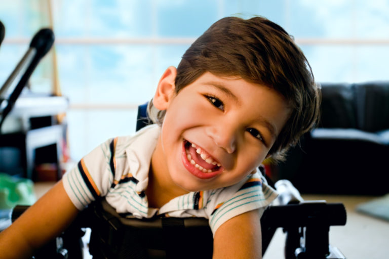 Disabled,Little,Boy,Standing,In,Walker,Smiling,And,Happily,Looking